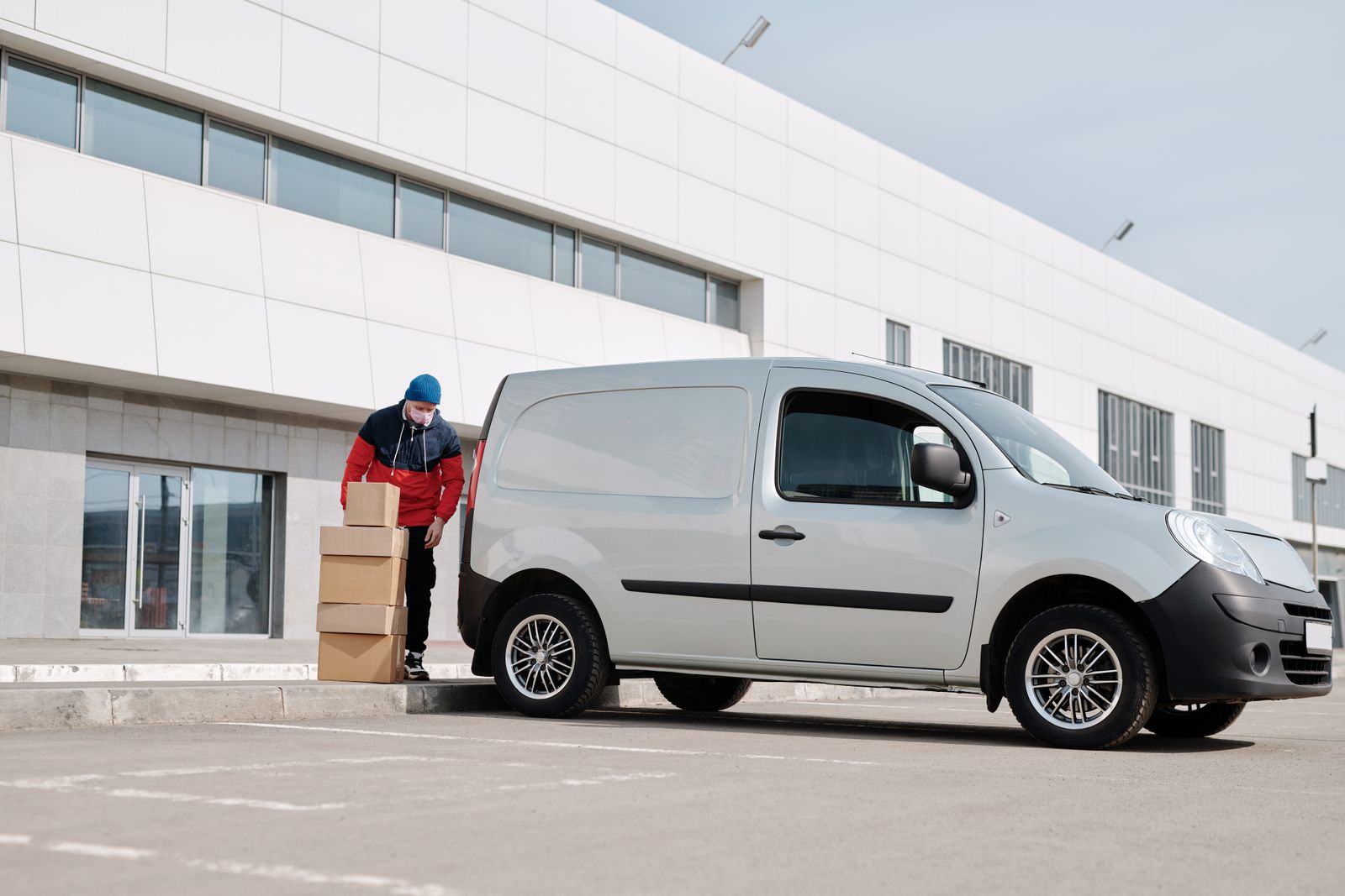 Courier loading parcels into a delivery van